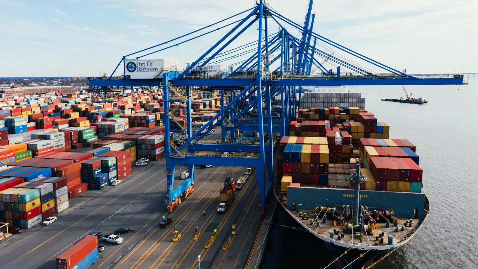 Container ship being loaded by gantry cranes at a terminal