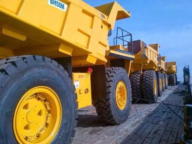 Mining dump trucks lashed on a barge deck