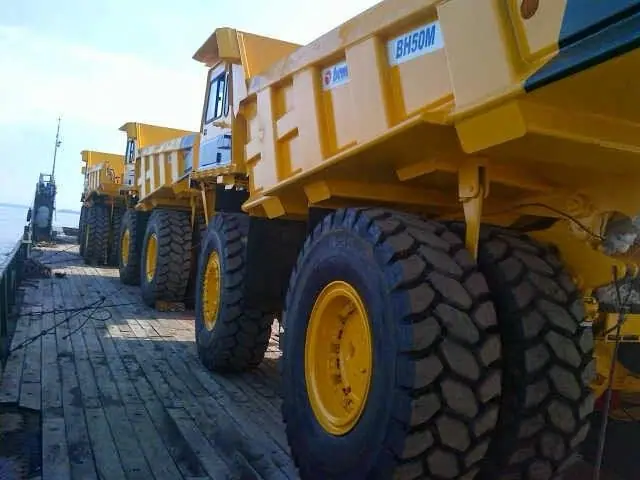 Mining dump trucks secured on a barge deck