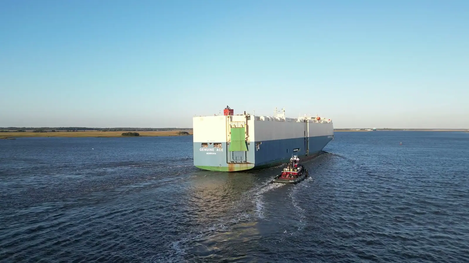 Aerial view of a Ro-Ro vehicle carrier under way with a tug in its wake