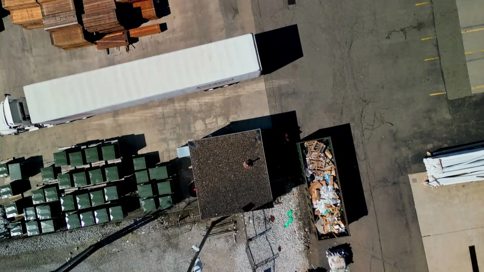 Overhead view of trucks, forklifts and stacked materials in a distribution yard